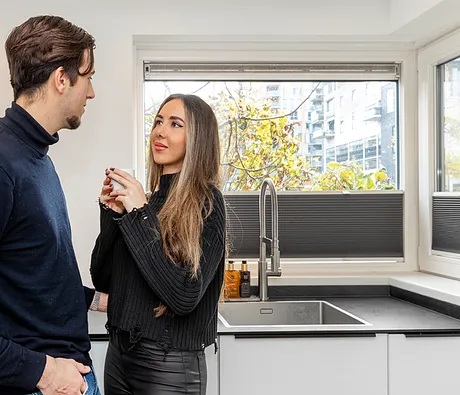 Man en vrouw genieten van kunststof kozijnen in moderne keuken