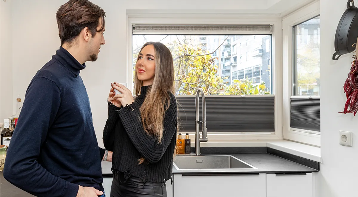Man en vrouw genieten van kunststof kozijnen in moderne keuken