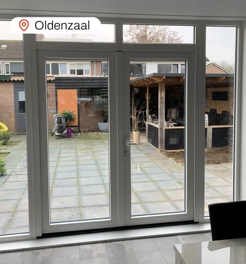 Kunststof openslaande deuren met bovenlichten en zijlichten in woonkamer woning Oldenzaal