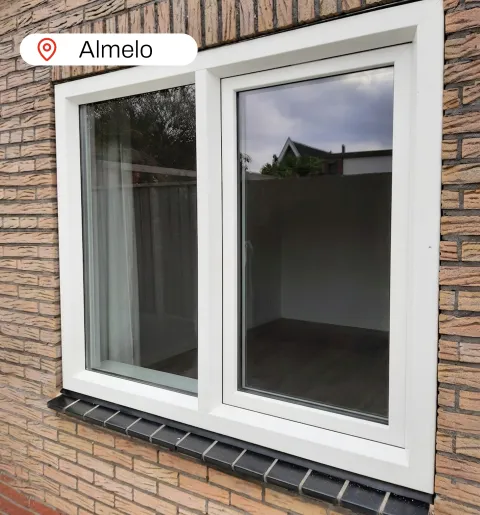 Wit kunststof kozijn in lichte stenen muur woning Almelo