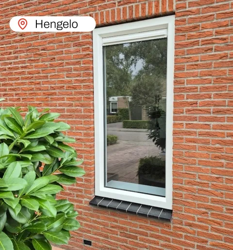 Wit kunststof kozijn in stenen muur