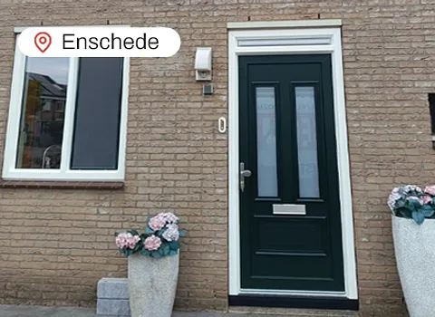 Voorgevel woning Enschede met kunststof kozijnen en groene kunststof voordeur