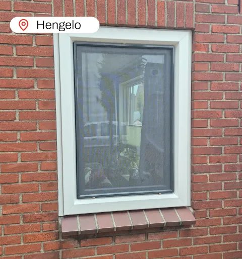 Wit kunststof kozijn in stenen gevel woning