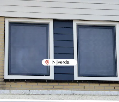 Wit met blauwe kunststof kozijnen en kunststof gevelbekleding in gevel woning NIjverdal
