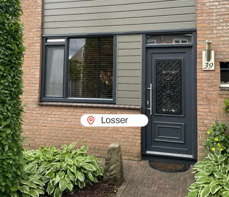 Voorgevel woning Losser met antracietgrijze kunststof kozijnen en kunststof voordeur en kwartsgrijze gevelbekleding