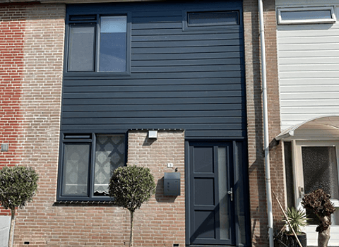 Voorgevel woning met kunststof kozijnen, kunststof voordeur en kunststof gevelbekleding antracietgrijs