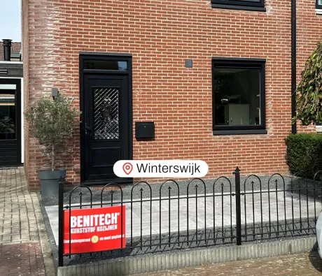Voorgevel woning met zwarte kunststof voordeur en zwart kunststof kozijn