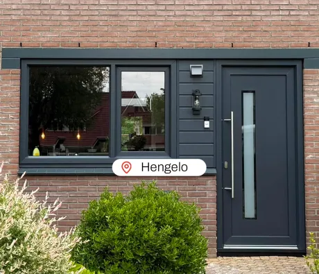 Antracietgrijze kunststof kozijnen en kunststof voordeur in voorgevel woning Hengelo