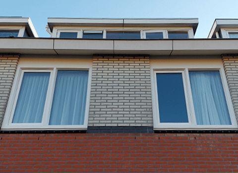 Witte kunststof kozijnen in gevel tweede verdieping woning