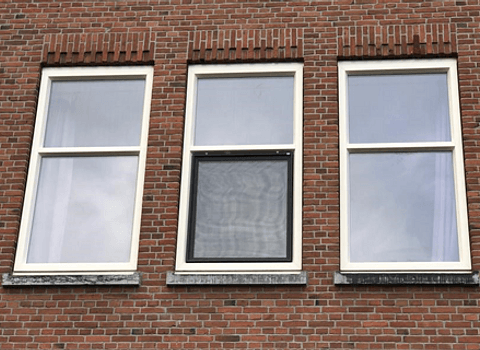 Drie kunststof raamkozijnen in stenen gevel
