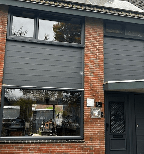 Voorgevel woning met kunststof kozijnen, deur en gevelbekleding in antracietgrijs