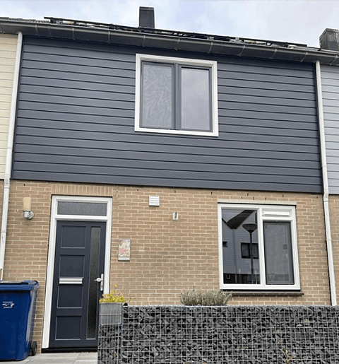 Voorgevel tussenwoning Almere met kunststof kozijnen, antraciet kunststof gevelbekleding en antraciet kunststof voordeur