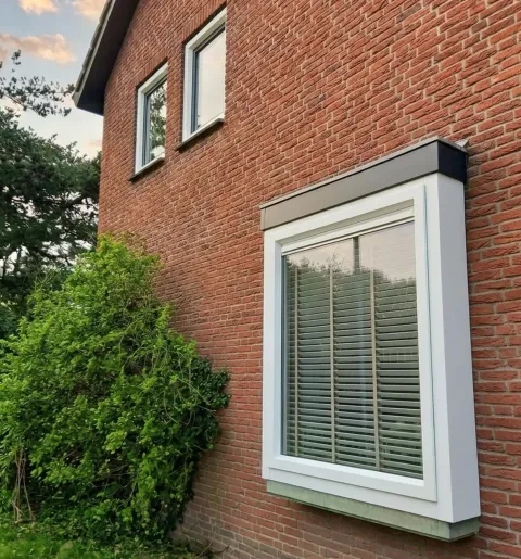 Gevel woning met kunststof bloemkozijn die verder naar voren zit dan de gevel