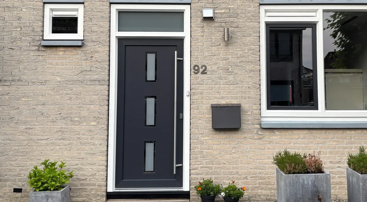 Voorgevel van een woning met kunststof voordeur en kunststof kozijnen