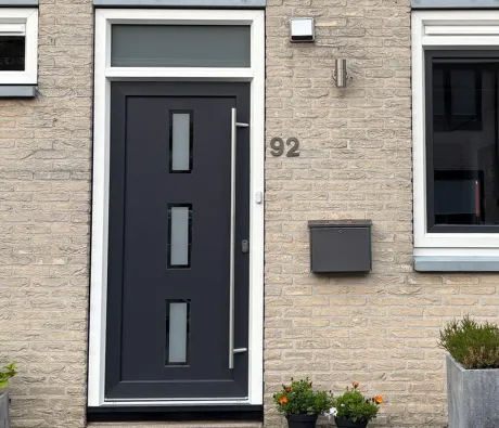 Voorgevel van een woning met kunststof voordeur en kunststof kozijnen