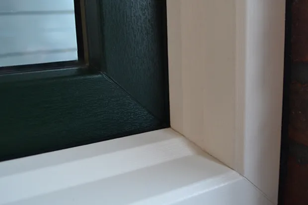 Kunststof kozijn houtnerf - Close up van kunststof kozijn met groen raam met houtnerf