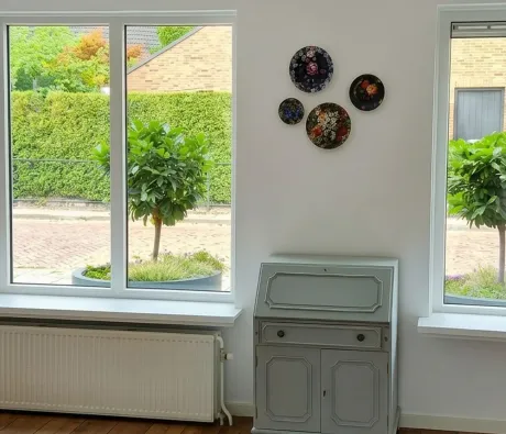 Woonkamer met witte kunststof kozijnen en een brede raampartij.