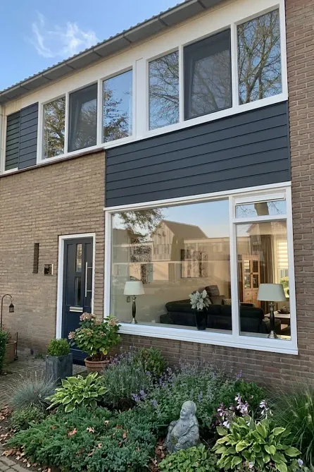 Buitenzijde van een woning met witte kunststof kozijnen.