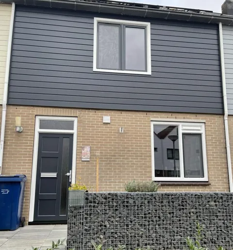Voorgevel woning met kunststof kozijnen ramen en deuren in wit en antracietgrijs