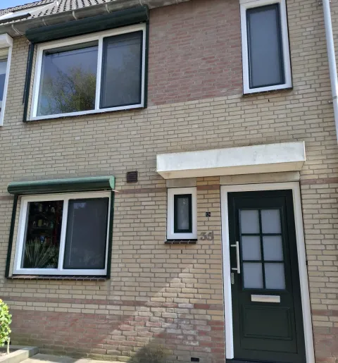 Voorgevel rijtjeswoning met kunststof kozijnen, ramen en deuren in wit met groen