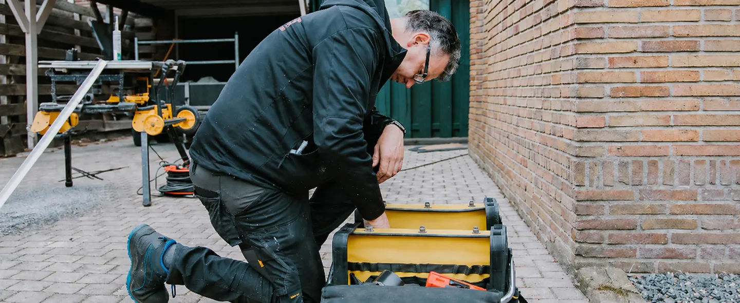 Servicemonteur Benitech Kozijnen pakt gereedschap uit gereedschapskist