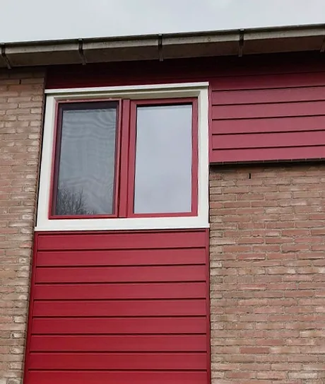 Rode kunststof gevelbekleding in gevel woning