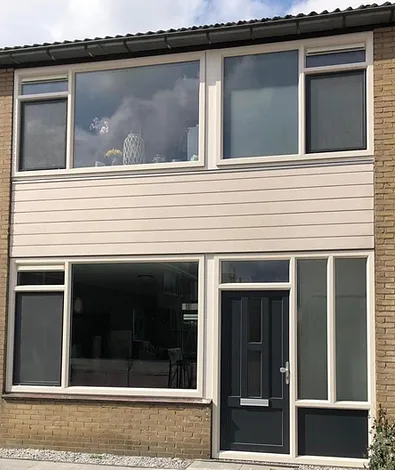 Voorgevel twee onder een kap woning met kunststof gevelbekleding, kunststof kozijnen en kunststof voordeur