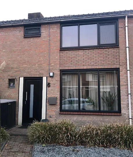 Voorgevel woning met kunststof kozijnen en kunststof voordeur jet black