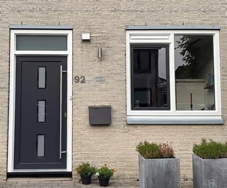 Buitenzijde voorgevel met kunststof voordeur en kunststof raamkozijn
