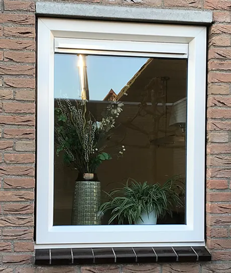 Wit kunststof kozijn van buiten met decoratie op de vensterbank