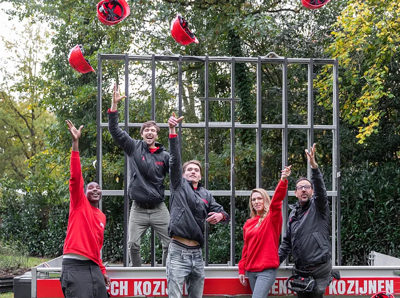 4 enthousiaste personeelsleden Benitech Kozijnen gooien bouwhelm in de lucht - wij zijn Benitech Kozijnen